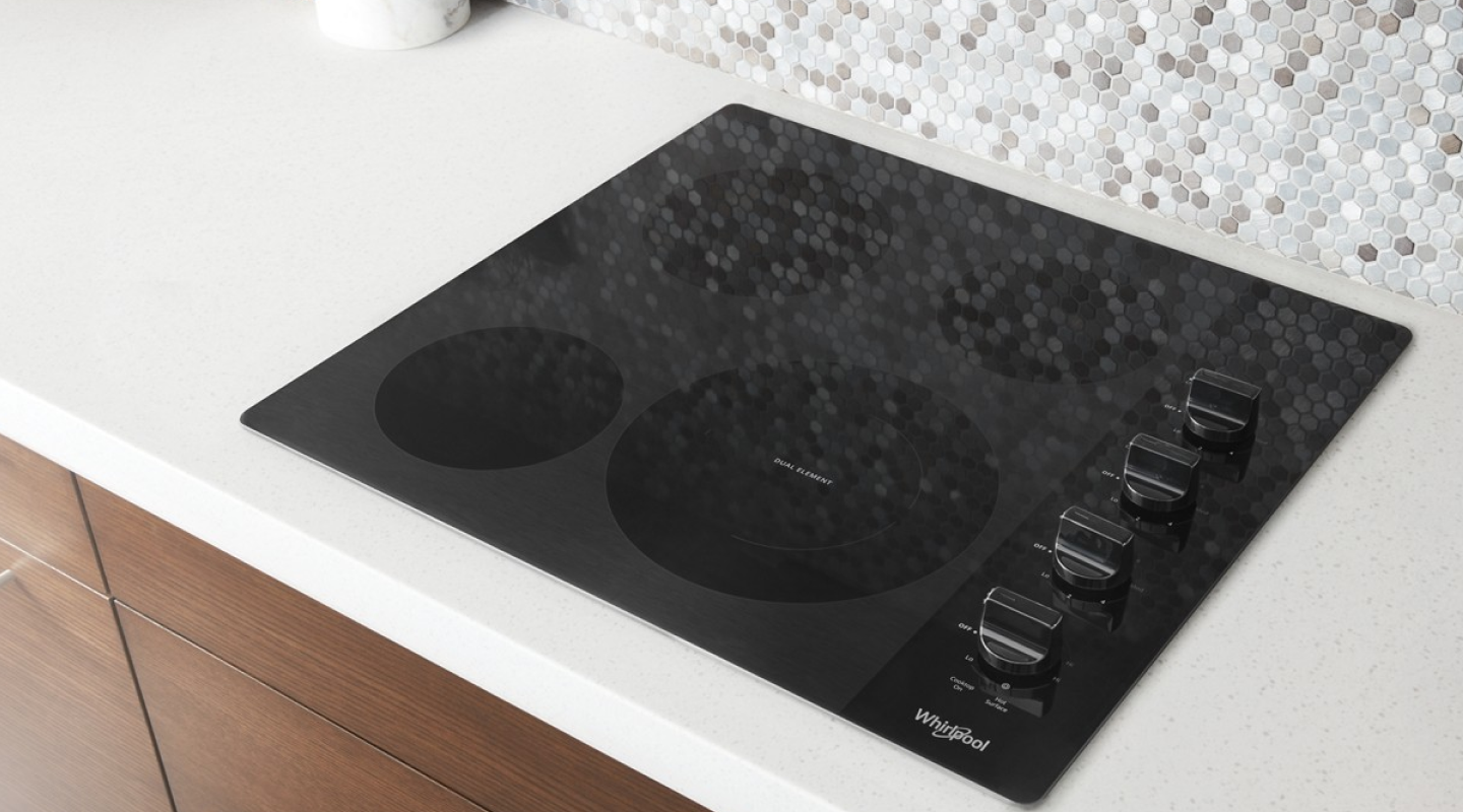 Whirlpool® electric cooktop built into a white countertop