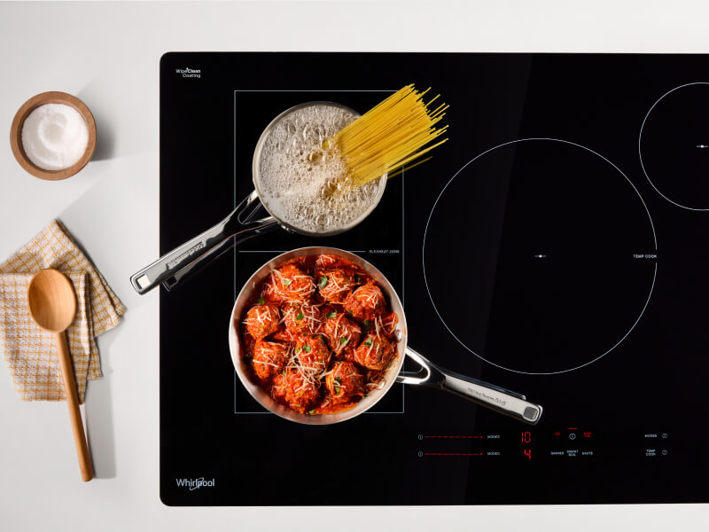 Noodles and meatball cooking on an induction cooktop