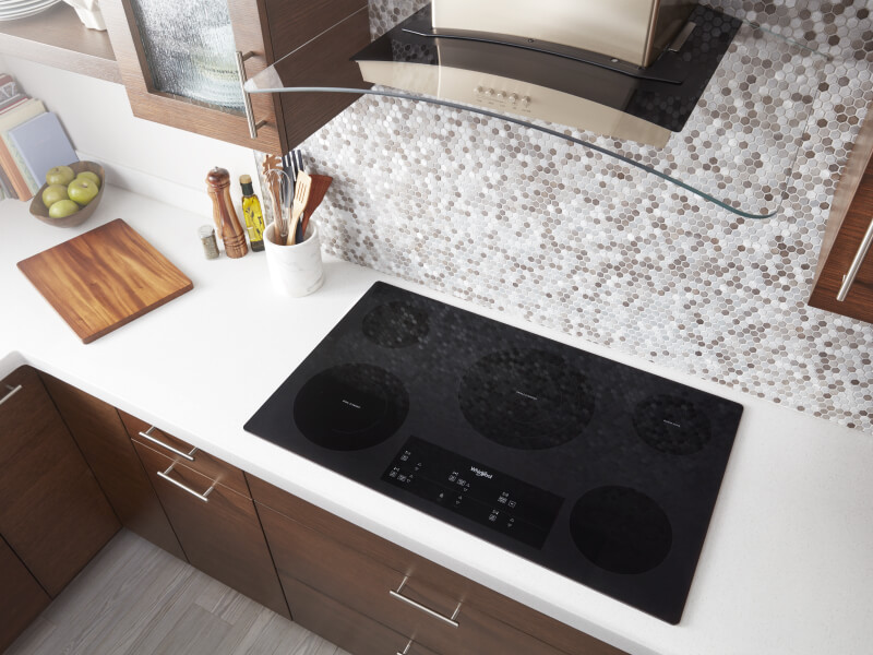 Bird’s-eye view on an induction cooktop below a range hood