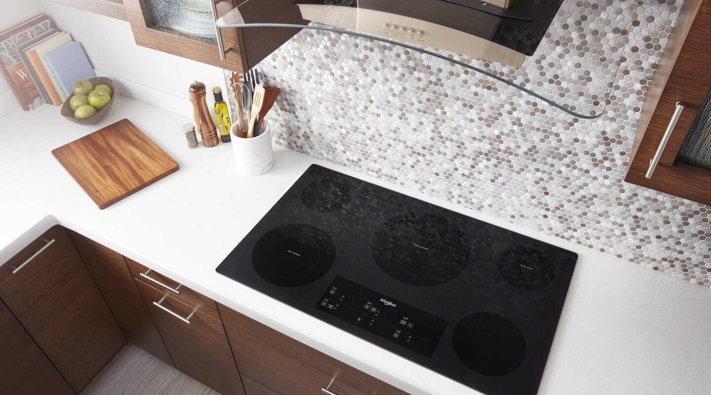 Bird’s-eye view on an induction cooktop below a range hood