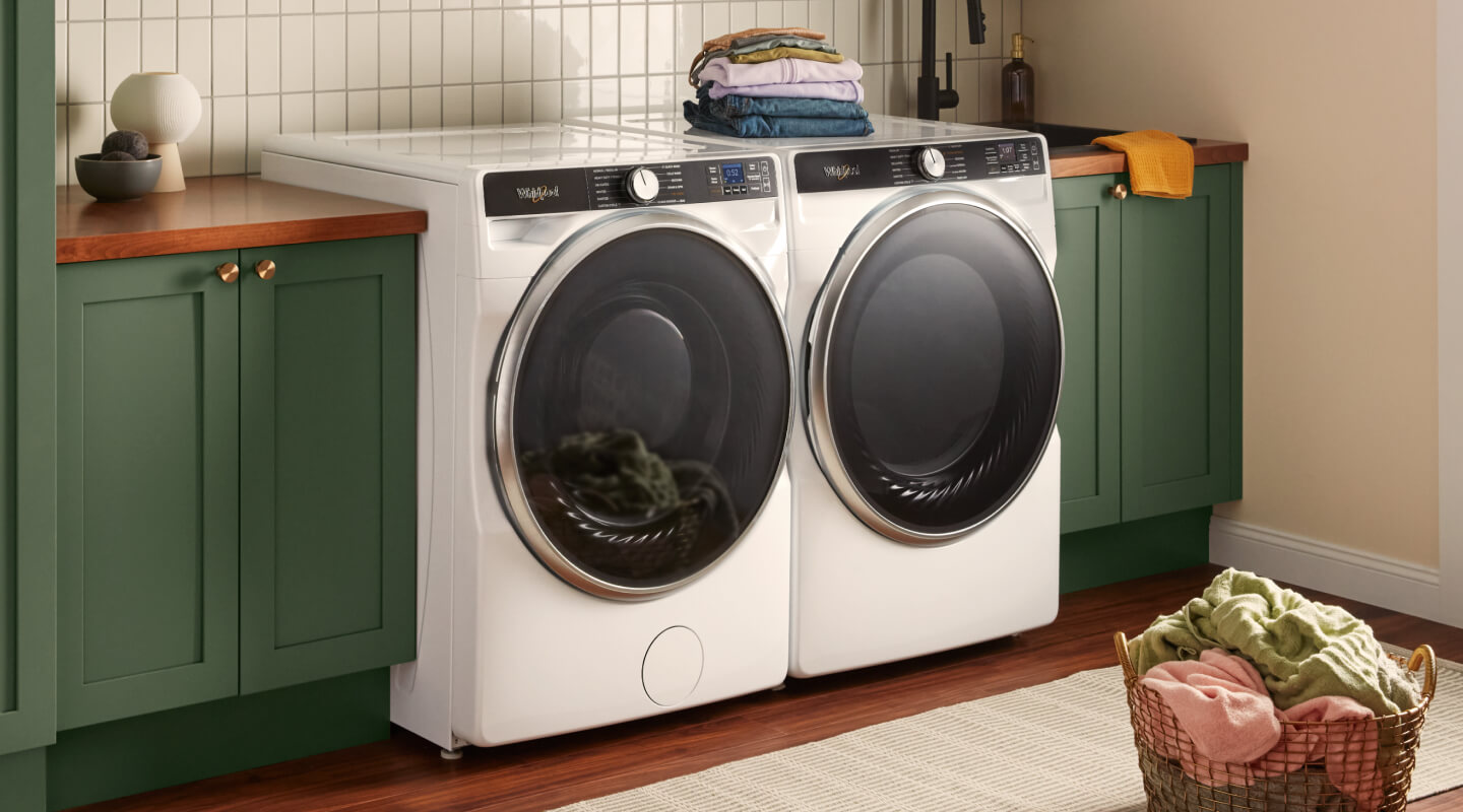 White Whirlpool® Front Load Washer and Dryer next to green cabinets