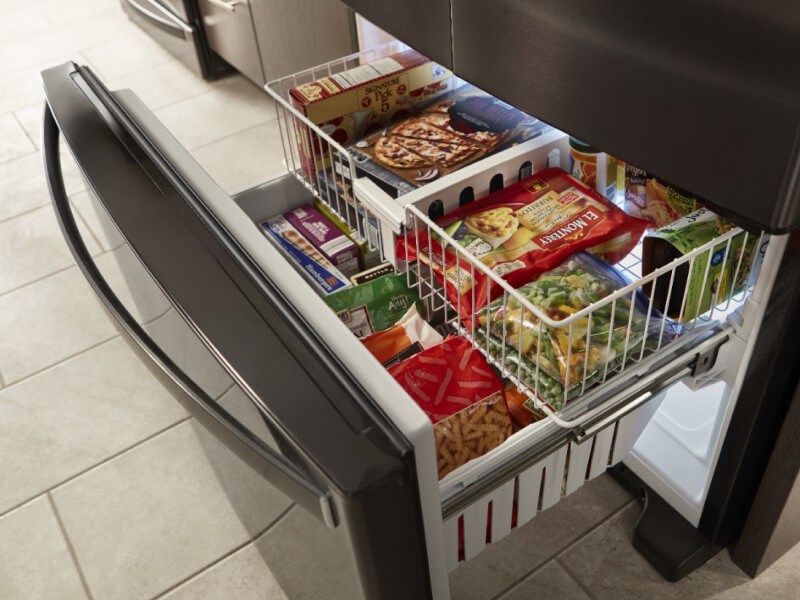 An open drawer on a bottom-freezer refrigerator