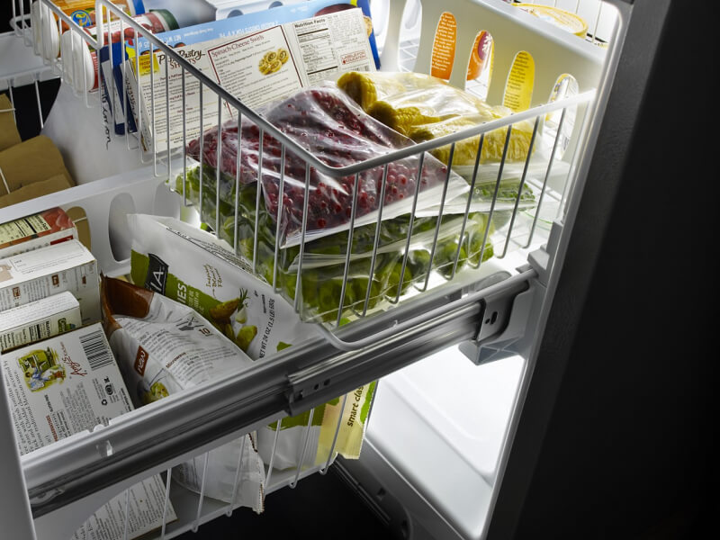 A tiered freezer drawer pulled out on a bottom-freezer refrigerator A tiered freezer drawer pulled out on a bottom-freezer refrigerator