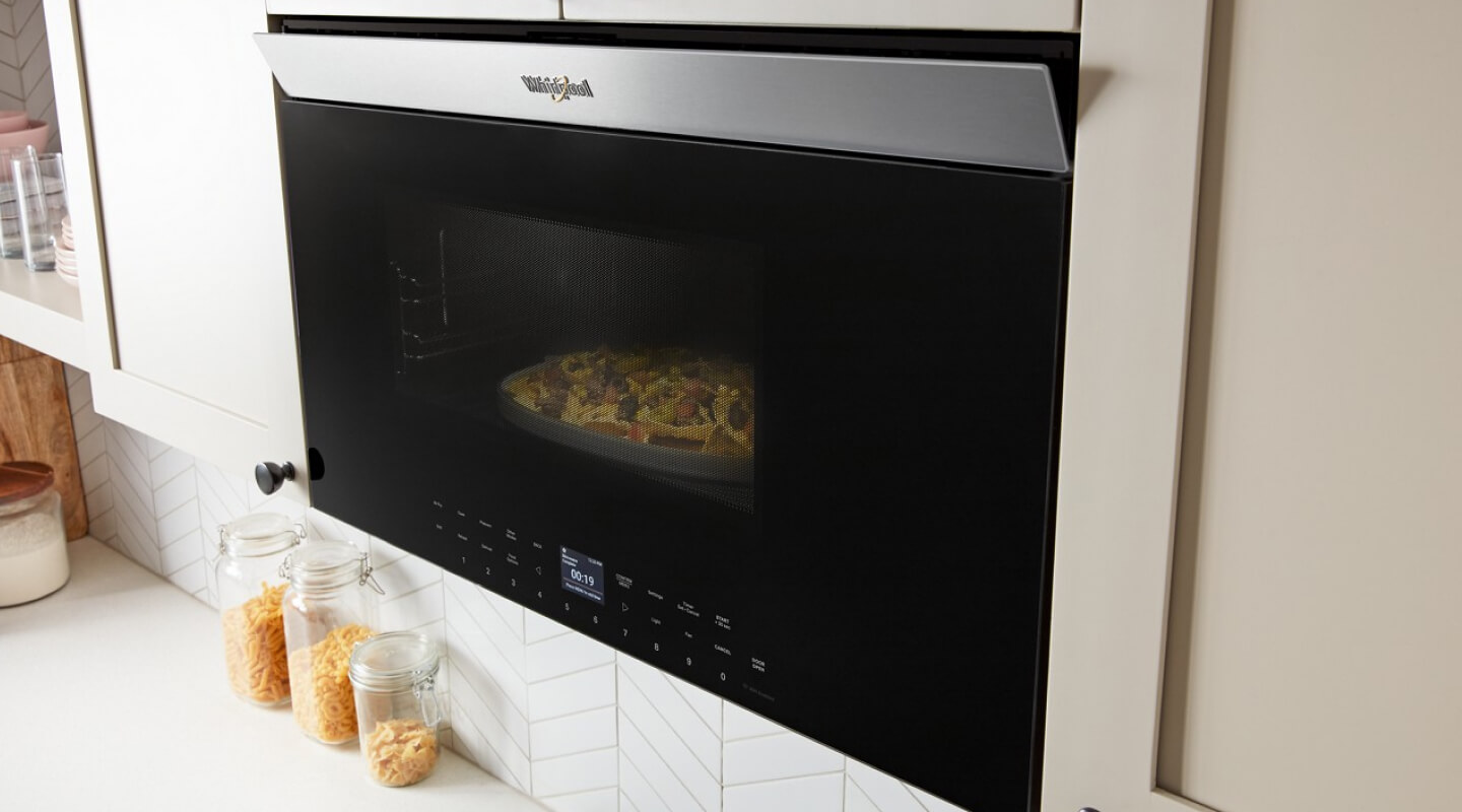 A Whirlpool® Air Fry Over- the-Range Oven in a modern white kitchen
