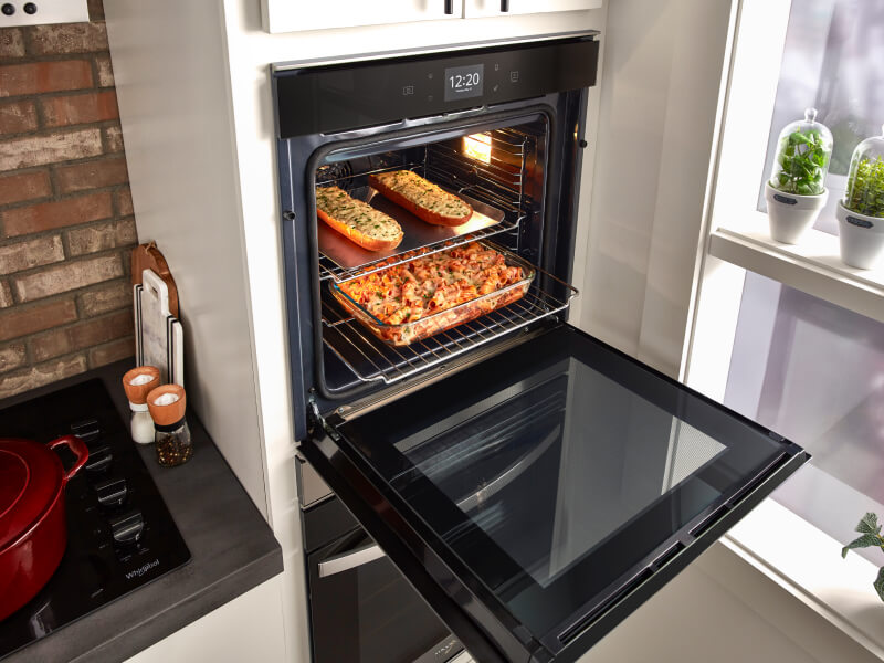An open double wall oven with food inside