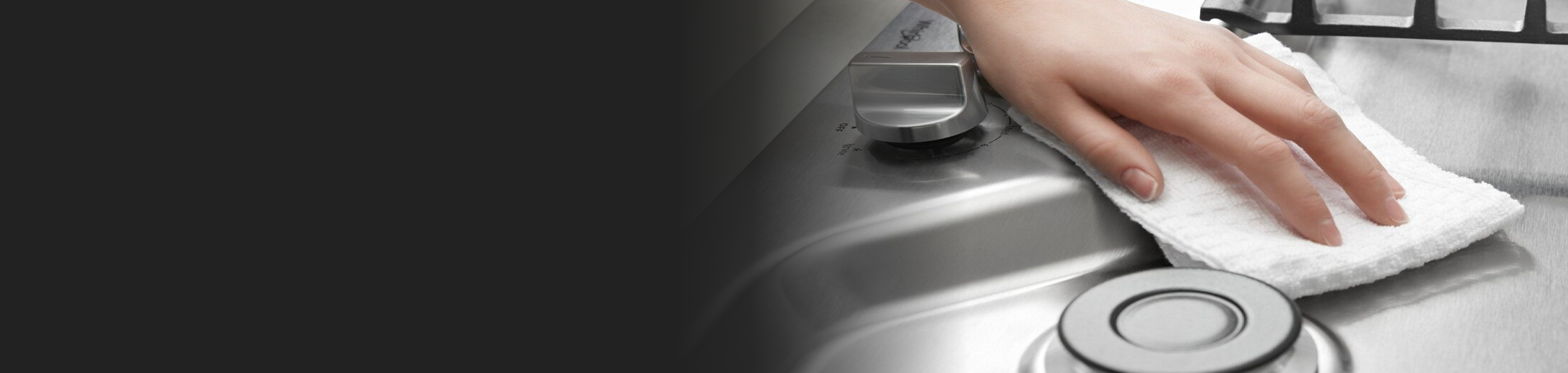 Person cleaning stainless steel cooktop