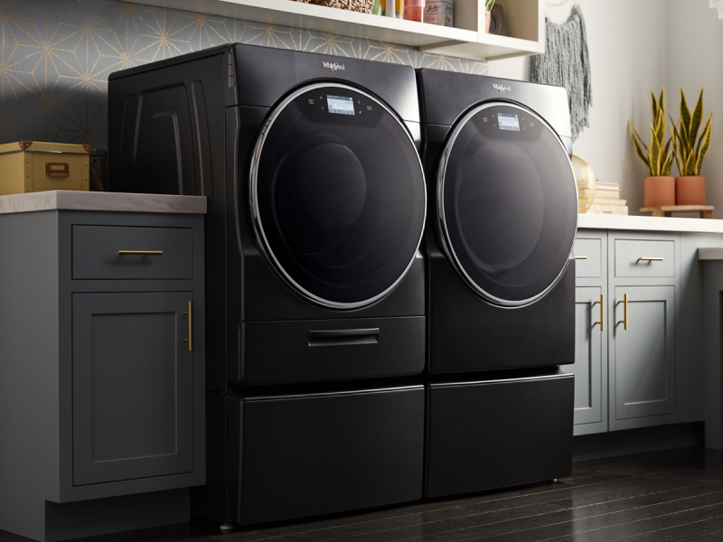 Whirlpool® Front Load Washer and Dryer in Black Shadow in a laundry room with gray cabinets Whirlpool® Front Load Washer and Dryer in Black Shadow in a laundry room with gray cabinets