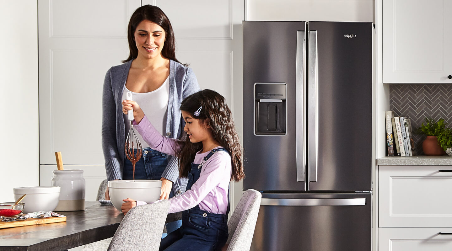 A woman and child mixing a bowl of batter A woman and child mixing a bowl of batter