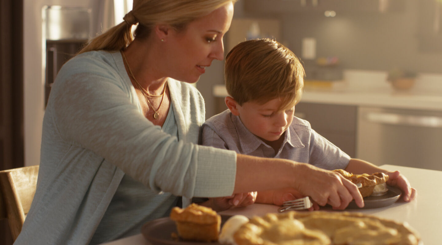 A mom serving her son a slice of pie A mom serving her son a slice of pie