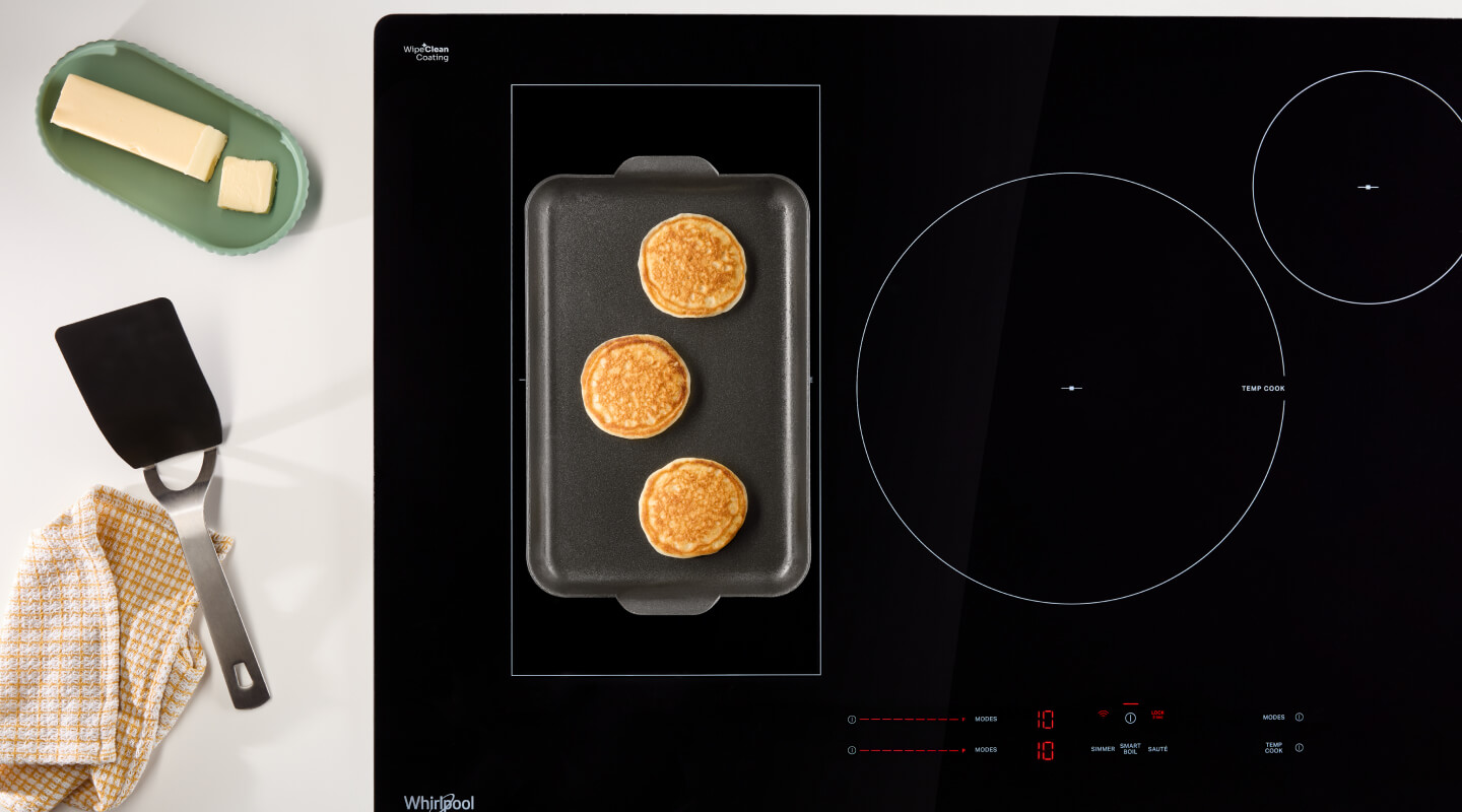 An overhead shot of a Whirlpool® Induction Cooktop cooking pancakes