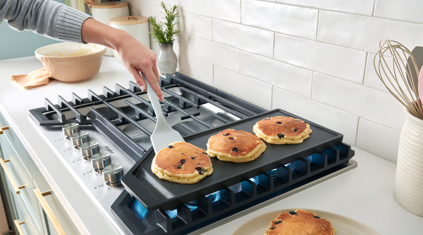 Pancakes cooking on a cooktop griddle