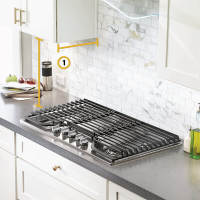 Gas cooktop set into gray countertop with measurements noted from below cabinets