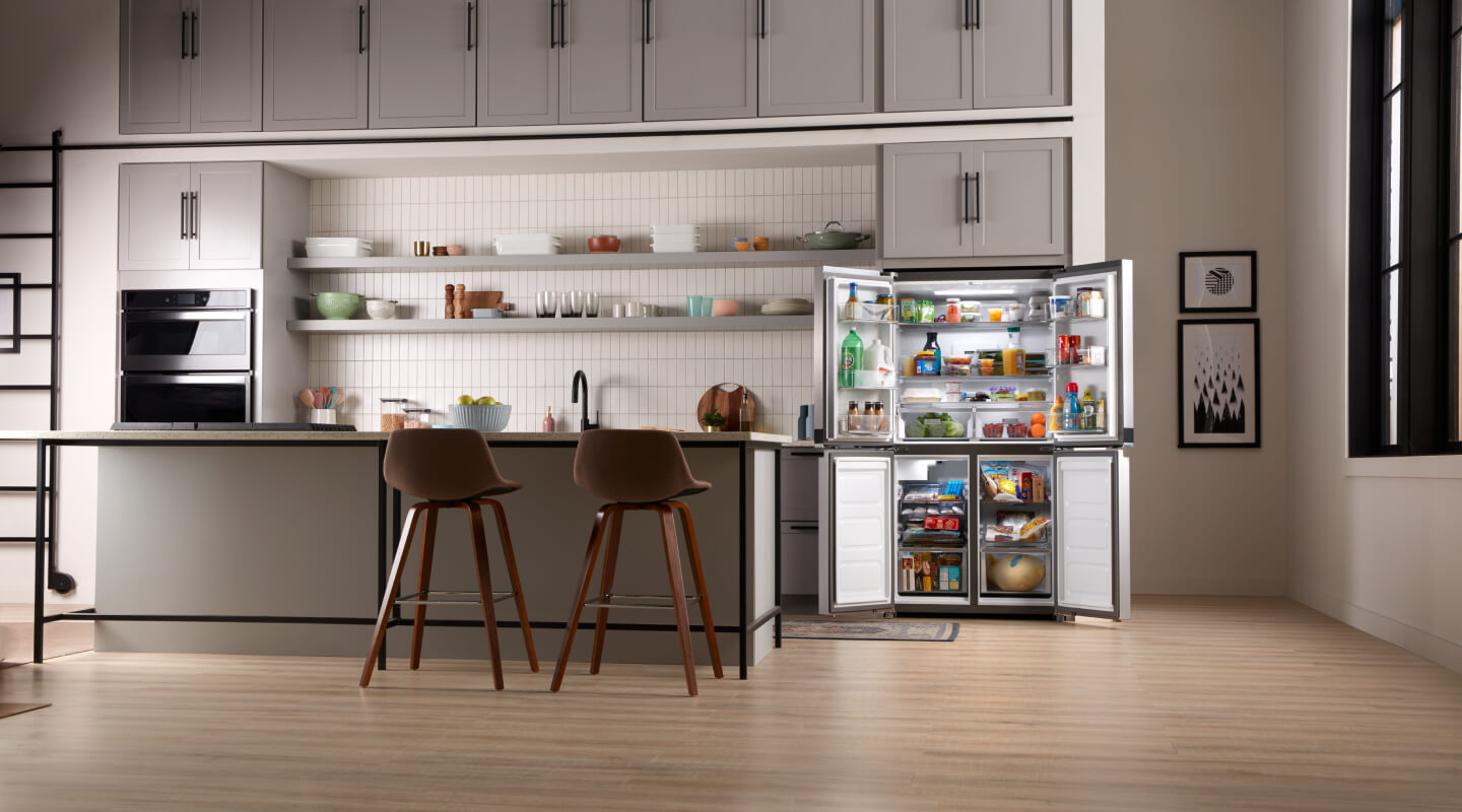 The inside of a kitchen with a counter-depth refrigerator shown with its doors open