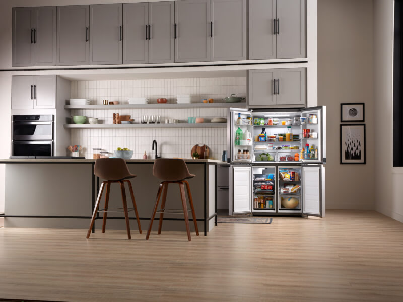 The inside of a kitchen with a counter-depth refrigerator shown with its doors open