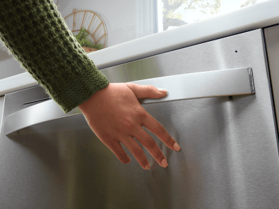 Person closing a dishwasher