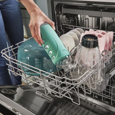 Person unloading a water bottle from the dishwasher