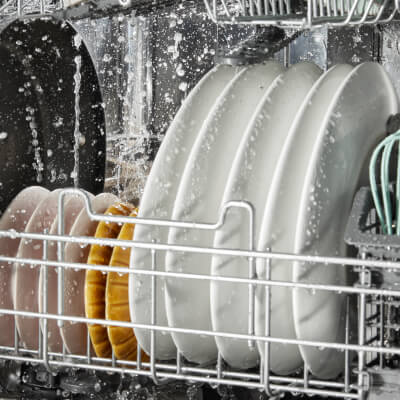 Stacked plates being cleaned inside a dishwasher