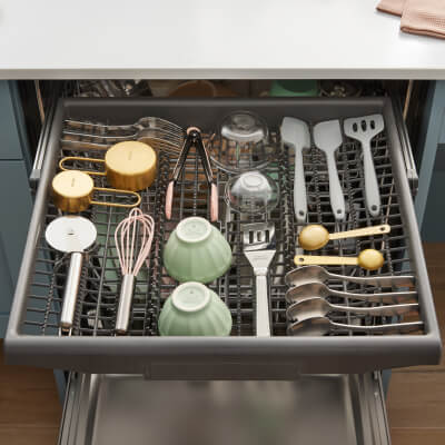 Miscellaneous utensils loaded in a dishwasher’s third rack