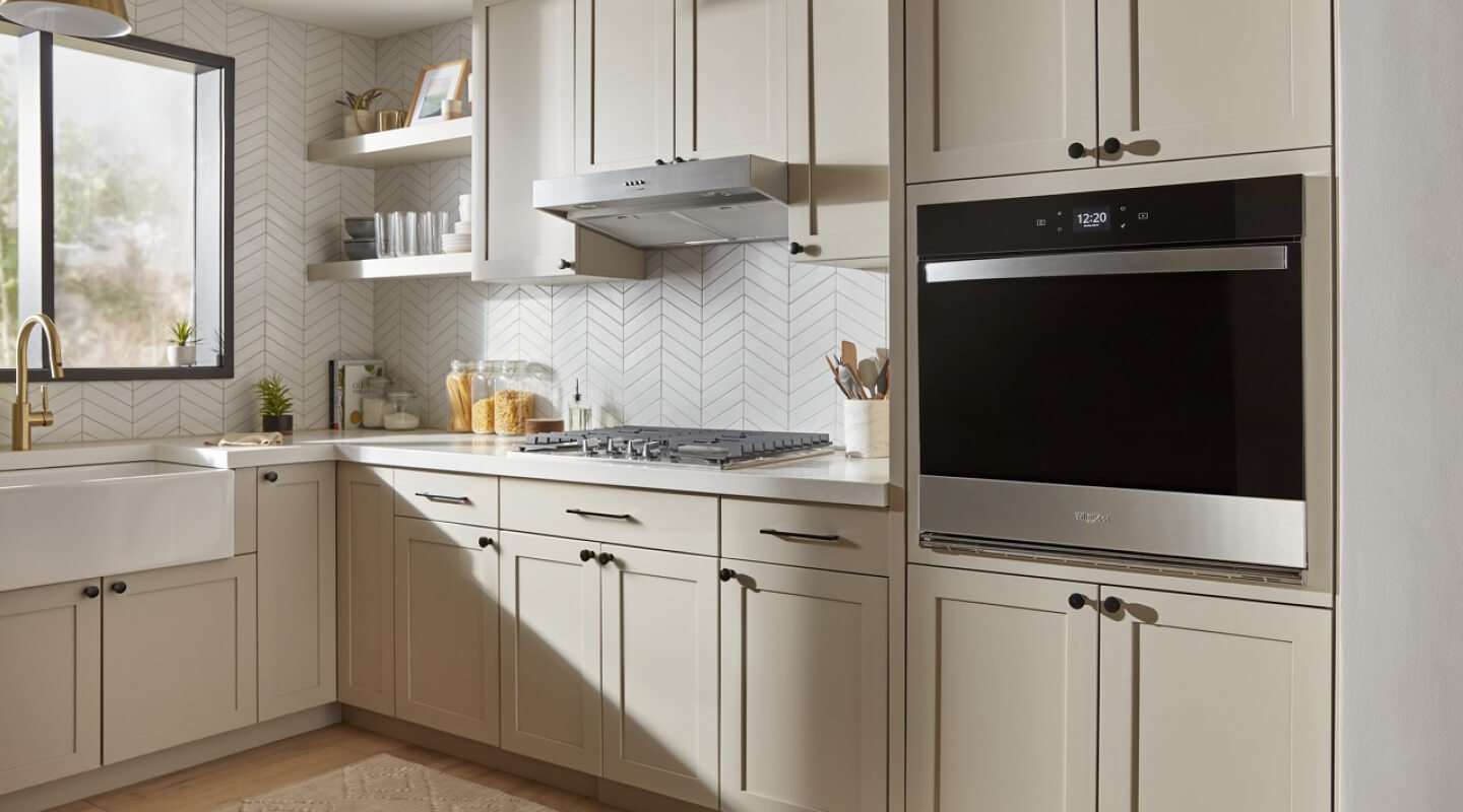 A Whirlpool® Single Wall Oven inside a beige and white kitchen