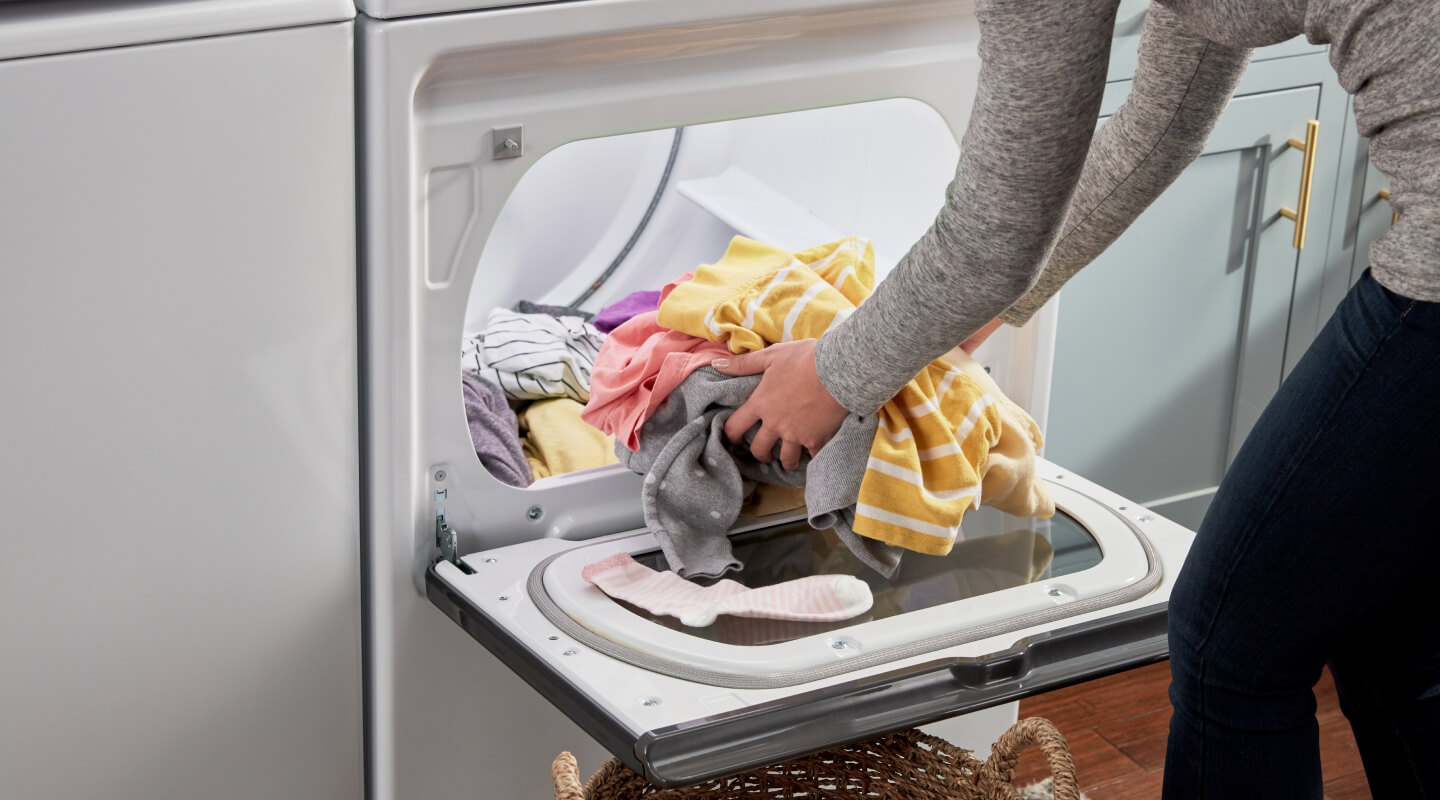 Person removing clothing from a dryer
