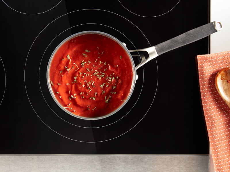 Tomato soup in a saucepan on an electric cooktop Tomato soup in a saucepan on an electric cooktop