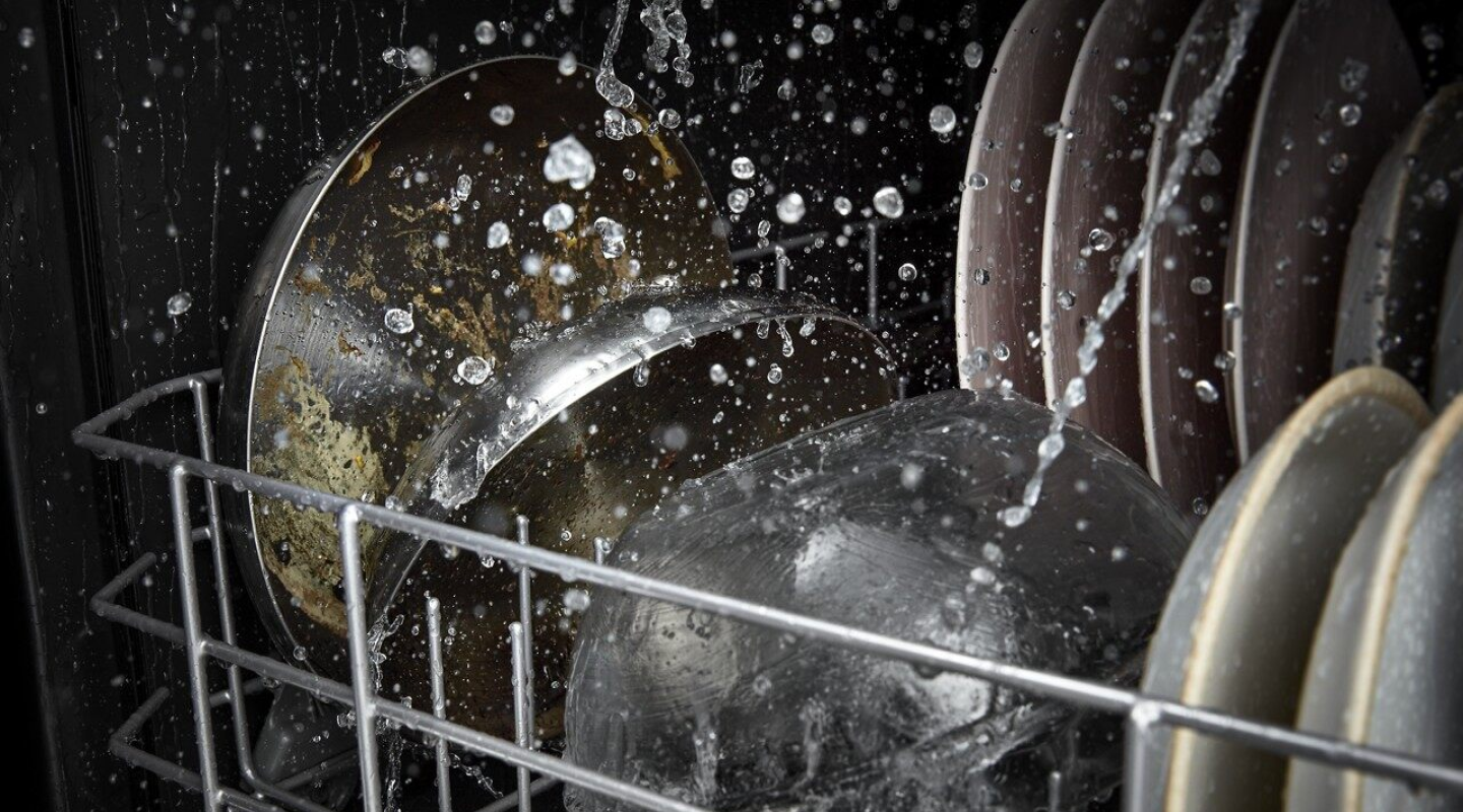 Dirty dishes going through a dishwasher cycle