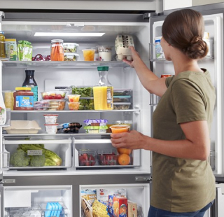 Person putting food inside a refrigerator