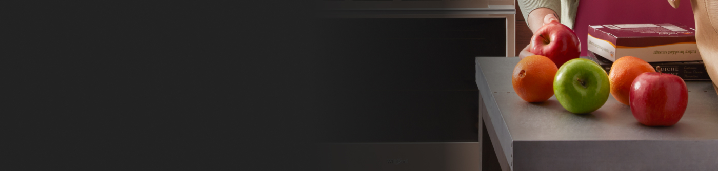 A person unloading apples on a counter