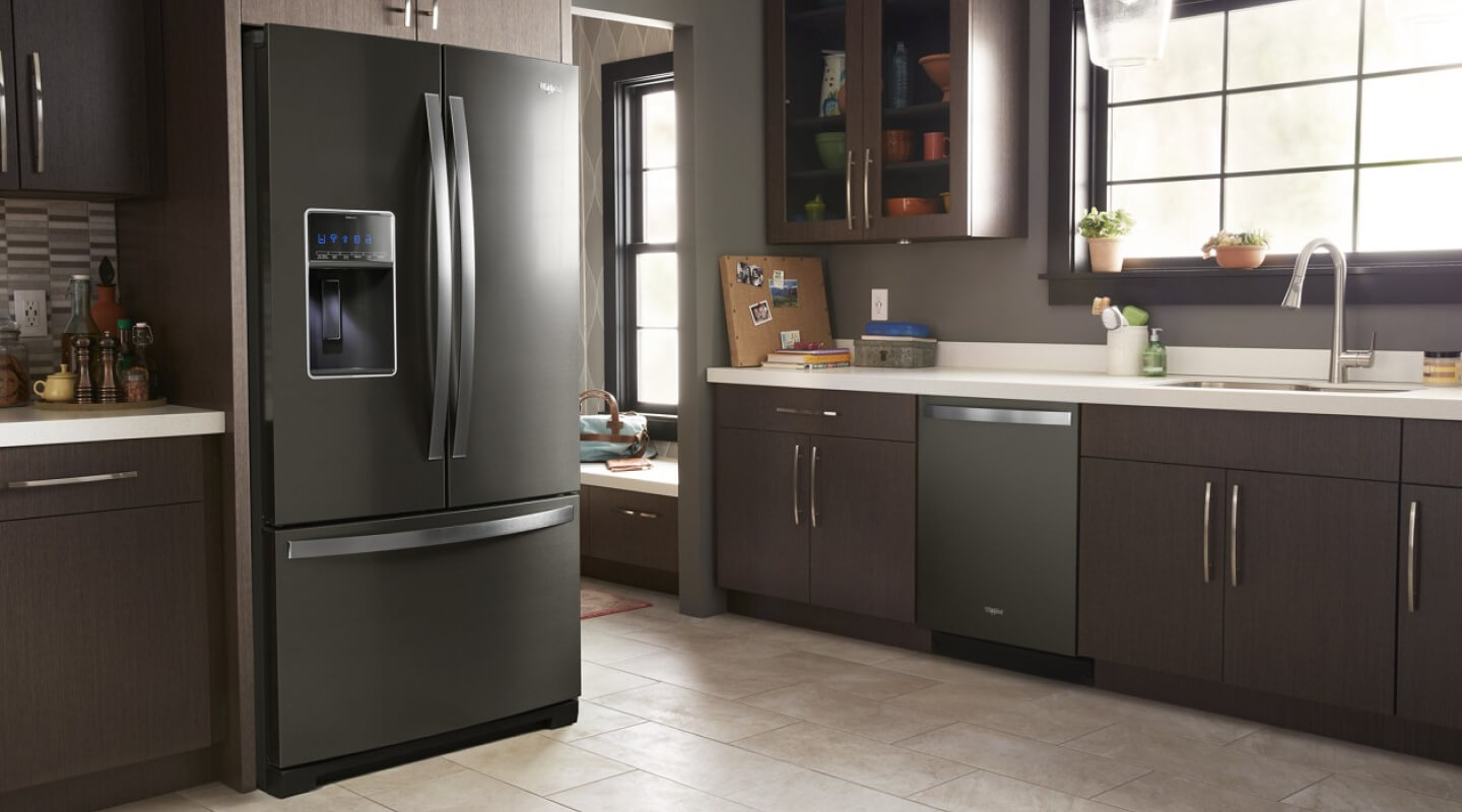 Black stainless steel Whirlpool® French Door Refrigerator in dark cabinetry