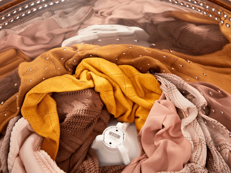 Orange- and pink-toned clothes inside of a Whirlpool® Washer with the 2 in 1 Removable Agitator Orange- and pink-toned clothes inside of a Whirlpool® Washer with the 2 in 1 Removable Agitator