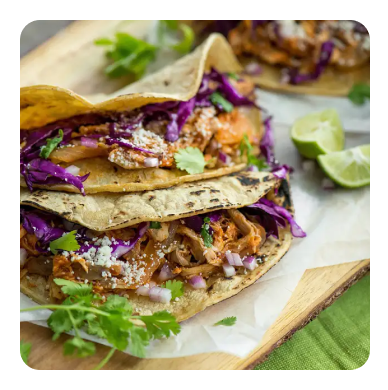 Saucy chicken pieces on a plate with sesame seeds and chopped scallions