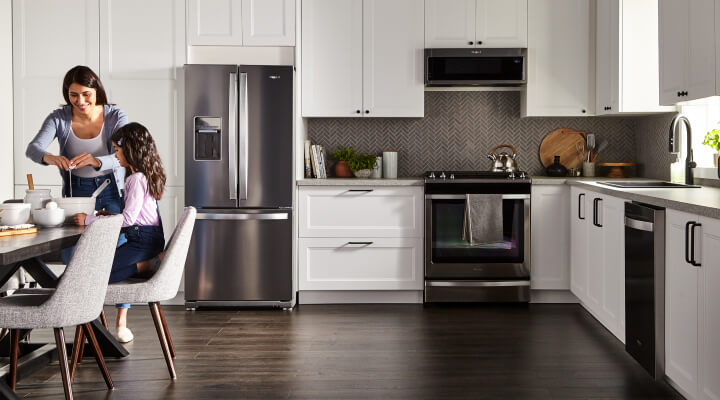 White kitchen featuring Whirlpool® Appliances in stainless steel 