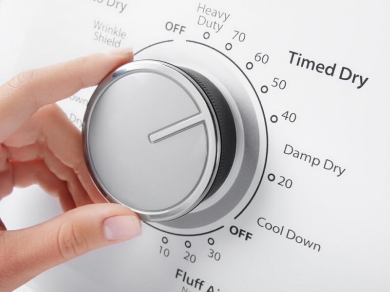 Person selecting a dryer cycle on a Whirlpool® Dryer