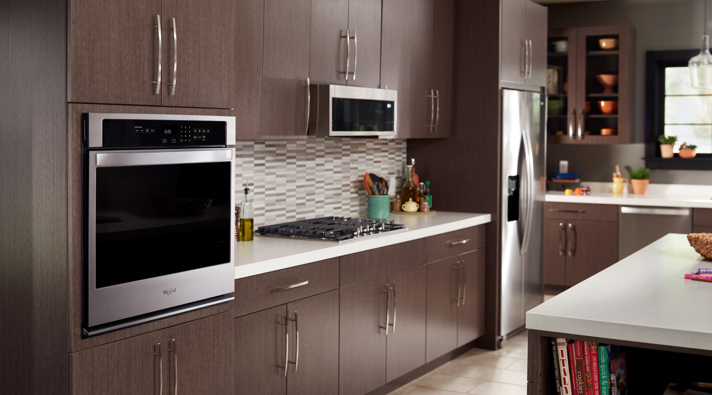 Overview of a kitchen with gas range, single wall oven and mounted microwave