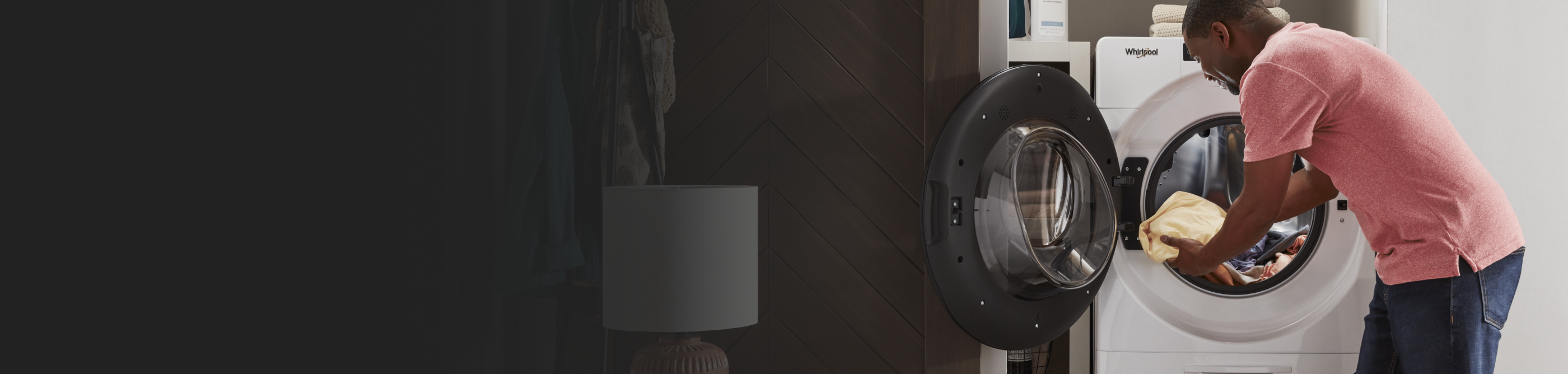 Person placing clothes into a Whirlpool® front load dryer. 