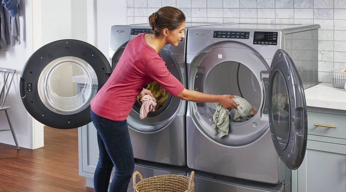 Person transfering items out of a washer into a dryer