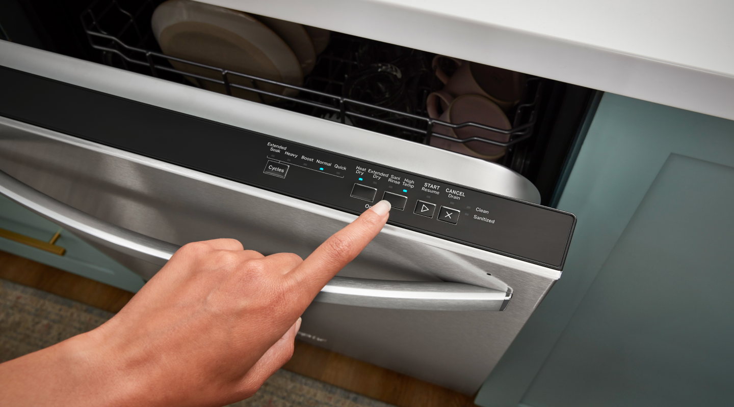 Person selecting a wash cycle on a Whirlpool® top control dishwasher