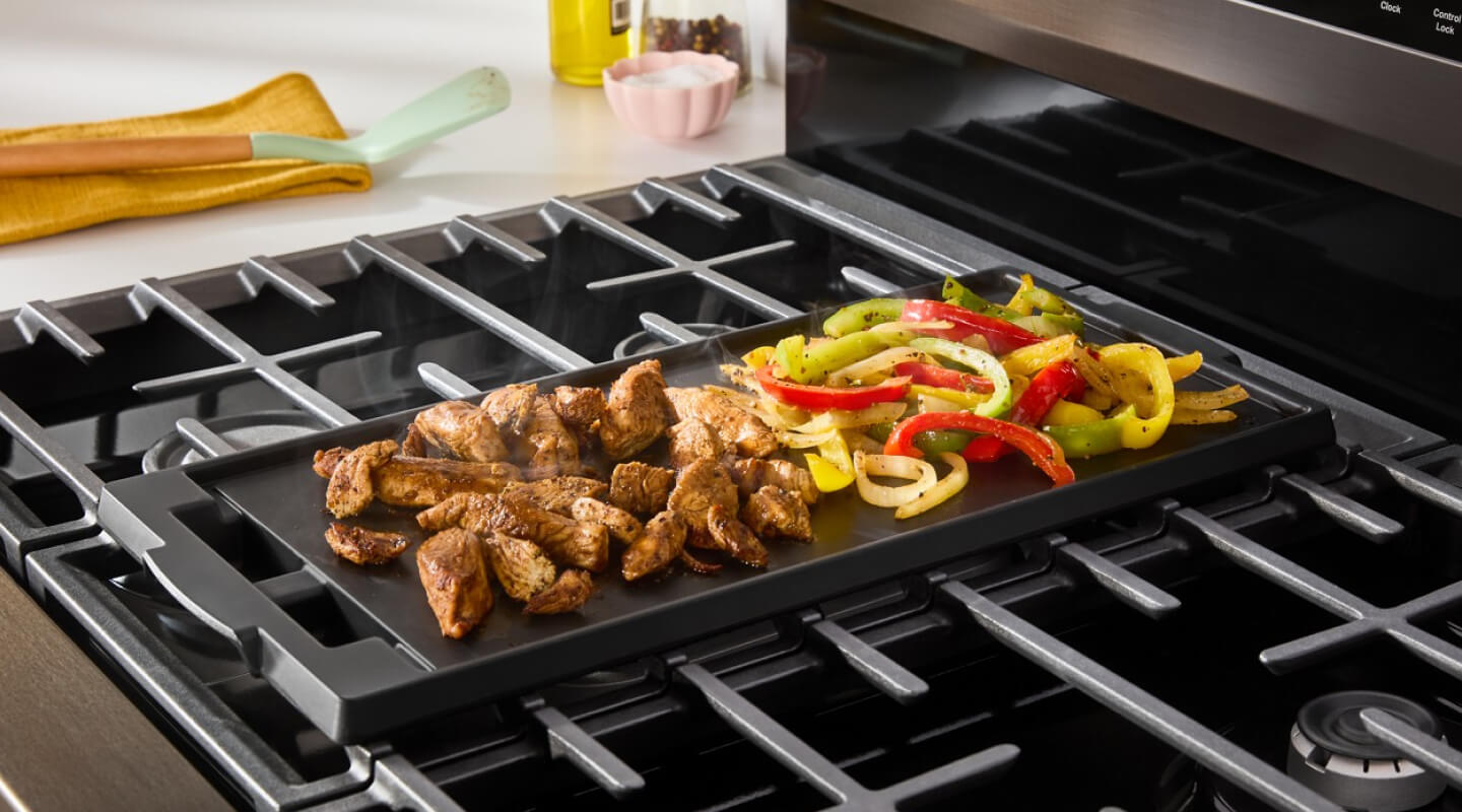 Chicken and vegetables grilling on range