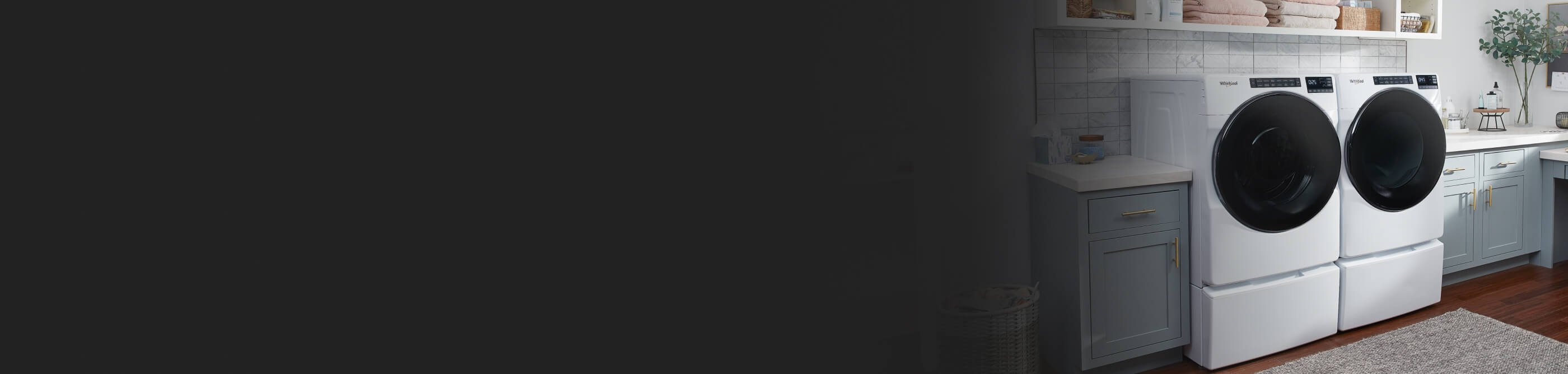 Laundry room with a white Whirlpool® front load laundry pair in blue cabinets and white counters