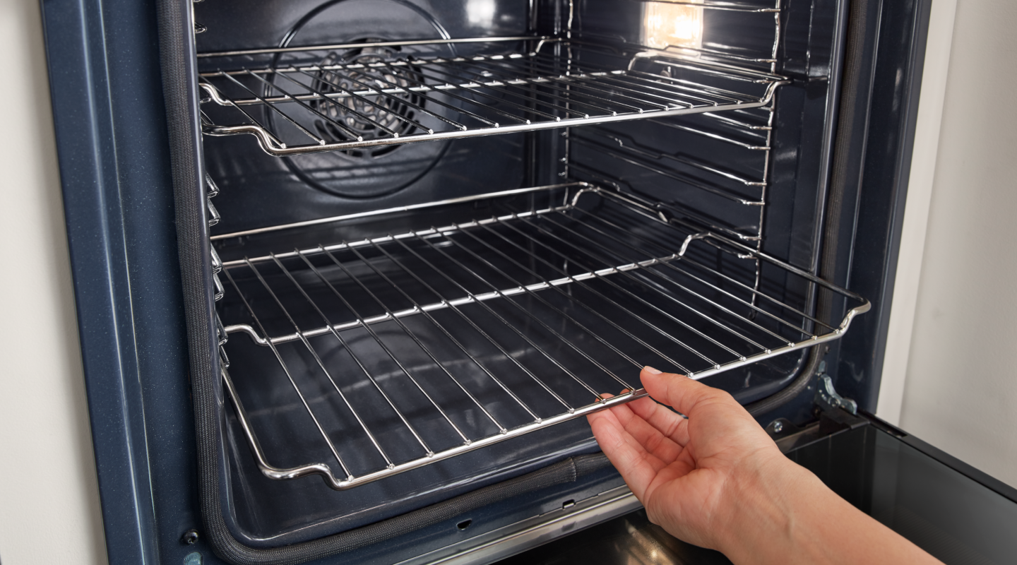 Person removing an oven rack from a Whirlpool® oven Person removing an oven rack from a Whirlpool® oven