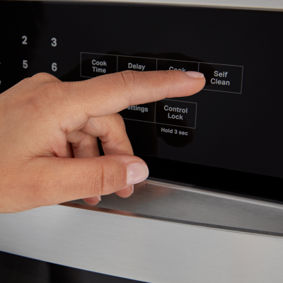 Person selecting a bake setting on a Whirlpool® oven