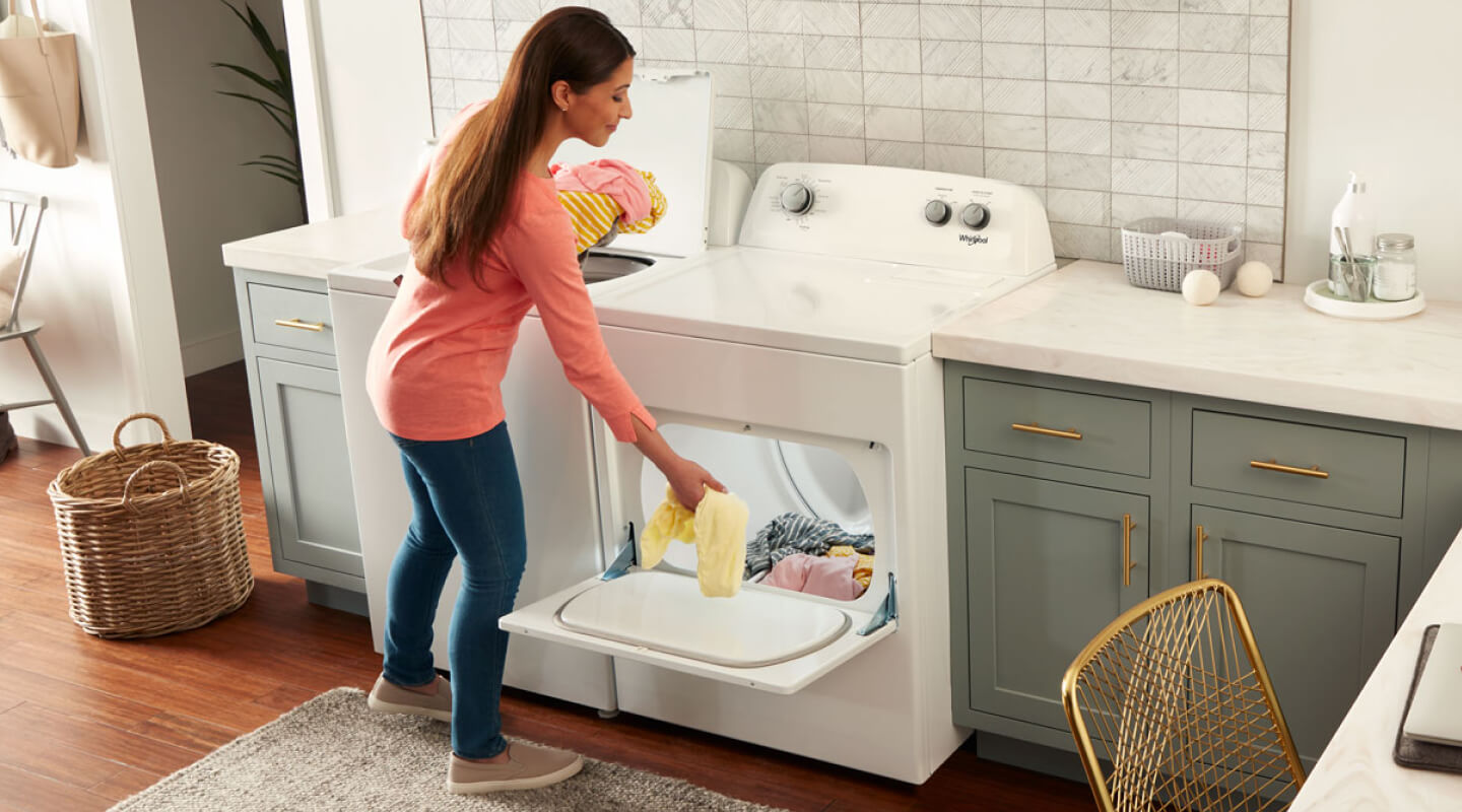 Woman loading clothes into a Whirlpool® dryer Woman loading clothes into a Whirlpool® dryer