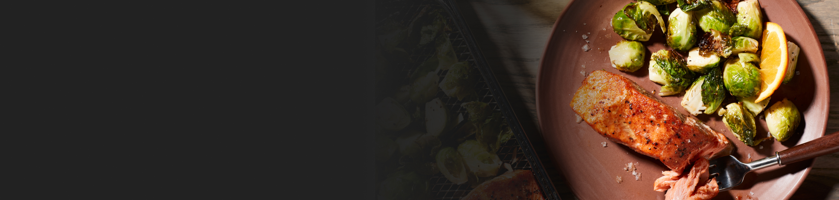 A closeup of air fried salmon on a plate with Brussel sprouts.