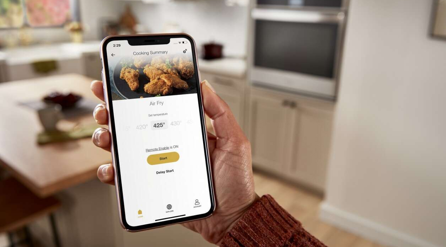 A closeup of a person holding a phone showing an online air fry recipe. A closeup of a person holding a phone showing an online air fry recipe.