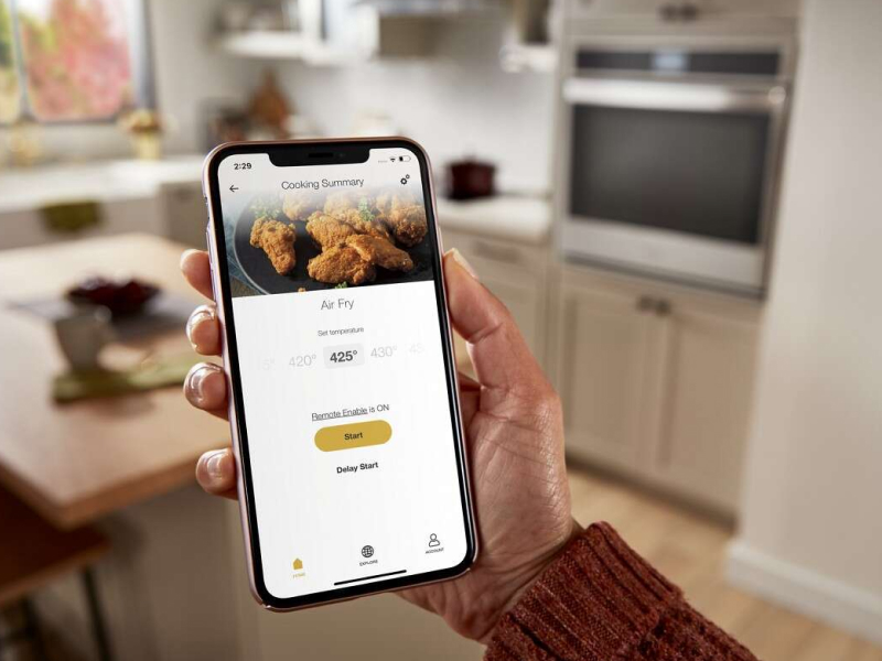 A closeup of a person holding a phone showing an online air fry recipe. A closeup of a person holding a phone showing an online air fry recipe.