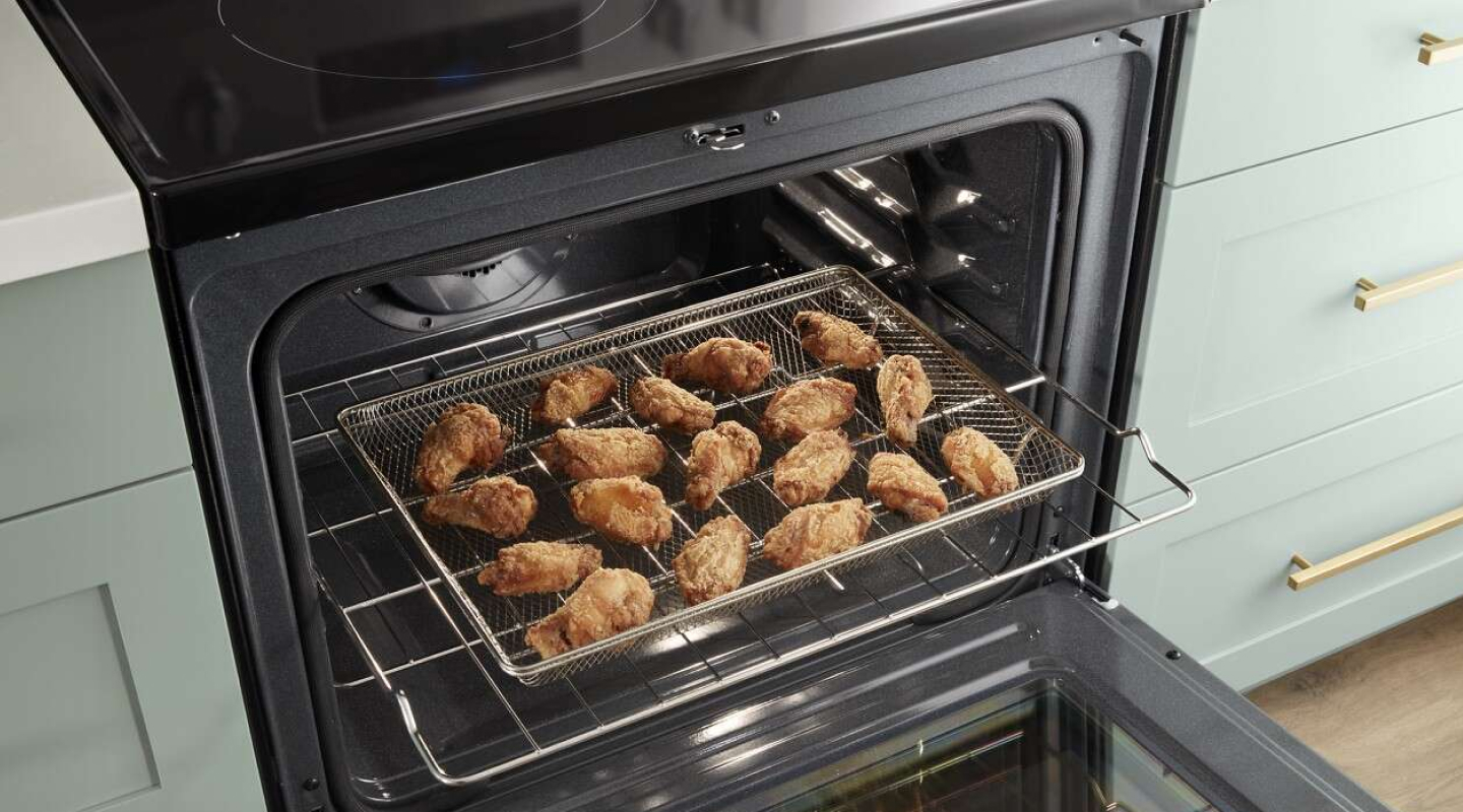 A closeup of a Whirlpool® oven with air fried food. A closeup of a Whirlpool® oven with air fried food.