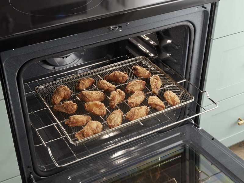 A closeup of a Whirlpool® oven with air fried food. A closeup of a Whirlpool® oven with air fried food.