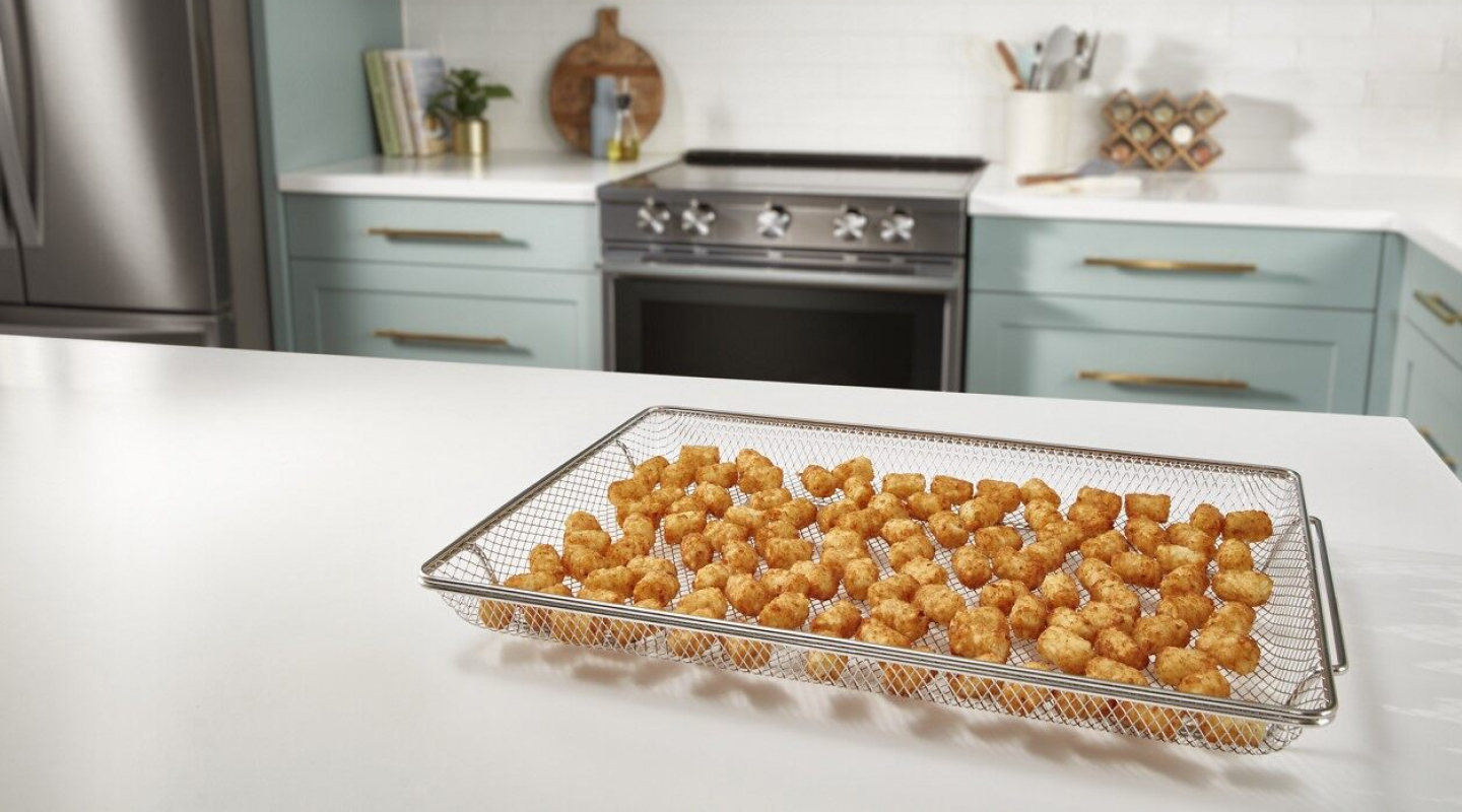 A basket with air fried food on a counter in a modern kitchen. A basket with air fried food on a counter in a modern kitchen.