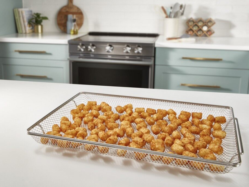 A basket with air fried food on a counter in a modern kitchen. A basket with air fried food on a counter in a modern kitchen.