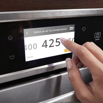 A finger setting an oven temperature